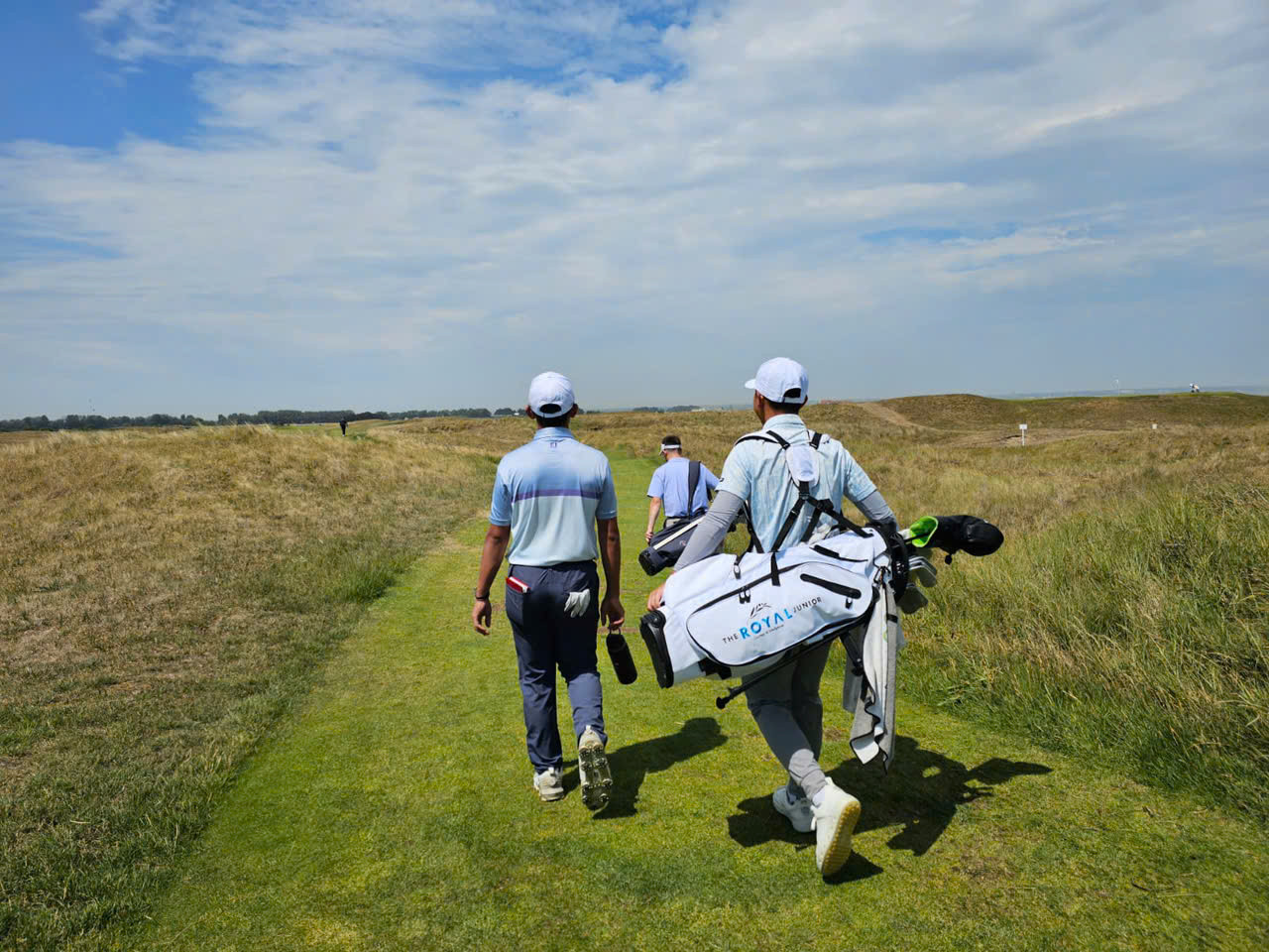 Nguyễn Anh Minh làm caddie cho bạn chơi người Singapore.