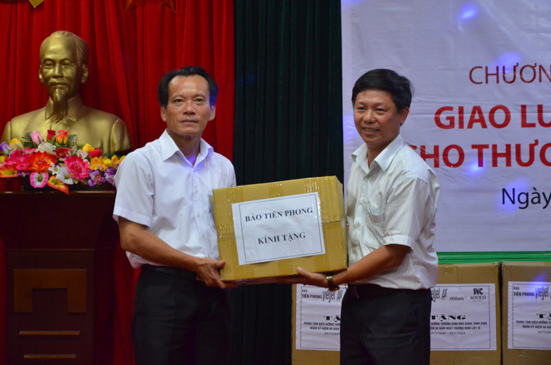 Phó tổng Biên tập báo Tiền Phong Trần Thanh Lâm (phải) trao quà của báo tới Trung tâm