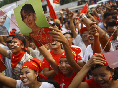 Cử tri Myanmar mang ảnh nhà lãnh đạo đối lập Aung San Suu Kyi đi bầu cử hôm 1-4. Ảnh: Getty Images
