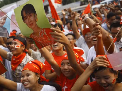 Cử tri Myanmar mang ảnh nhà lãnh đạo đối lập Aung San Suu Kyi đi bầu cử hôm 1-4. Ảnh: Getty Images