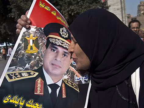 Một phụ nữ Ai Cập hôn chân dung Tướng Sisi