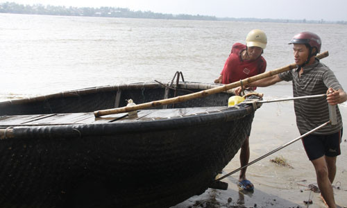 Ngư dân thị trấn Cửa Tùng (H.Vĩnh Linh, Quảng Trị) tranh thủ lúc bão chưa vào để kéo thuyền thúng lên bờ - Ảnh: Nguyễn Phúc - TNO