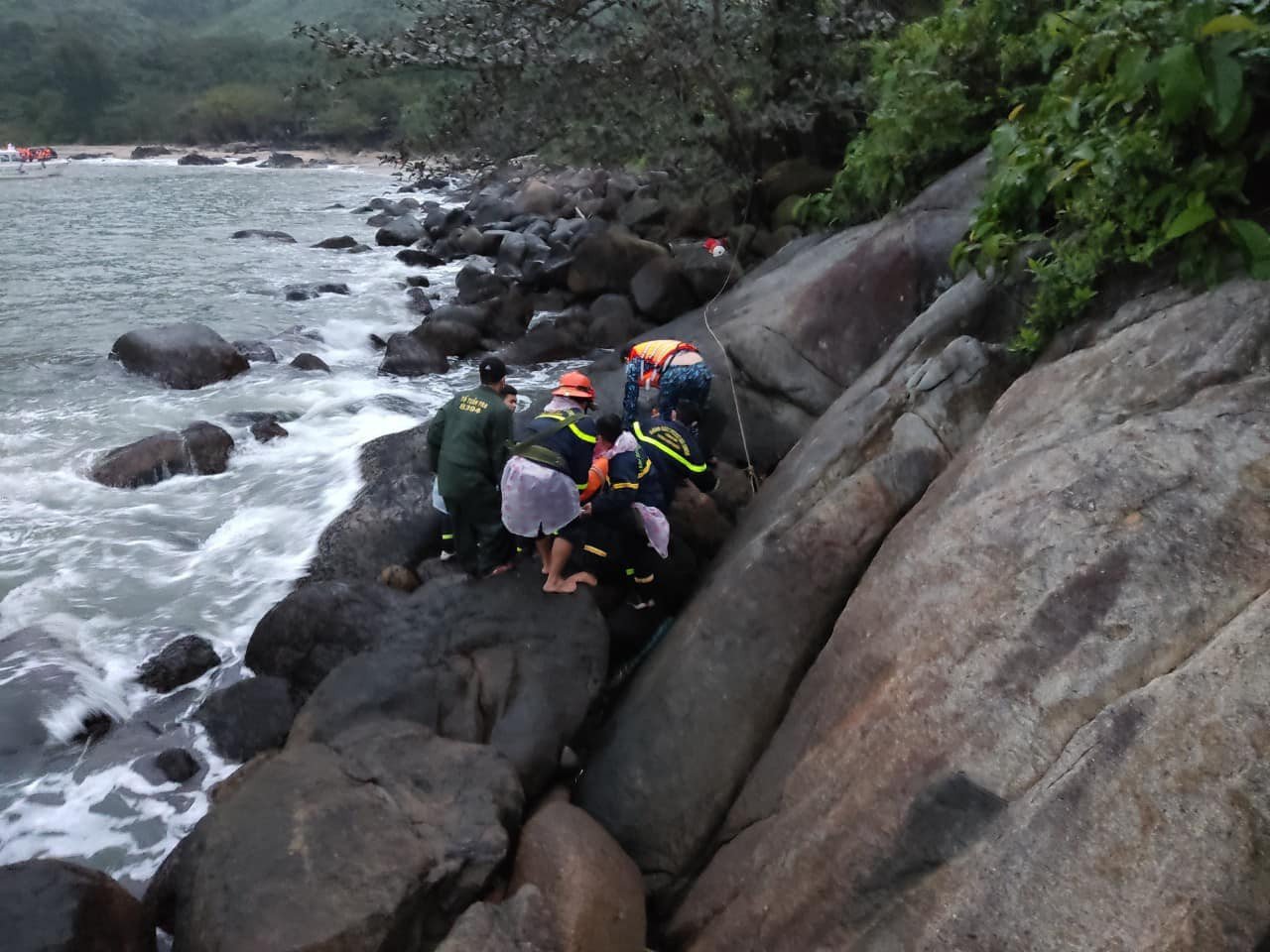 Lực lượng cứu hộ di chuyển nạn nhân bằng cáng vượt qua bãi đá để đưa lên cano về cảng sông Hàn. Ảnh: C.A