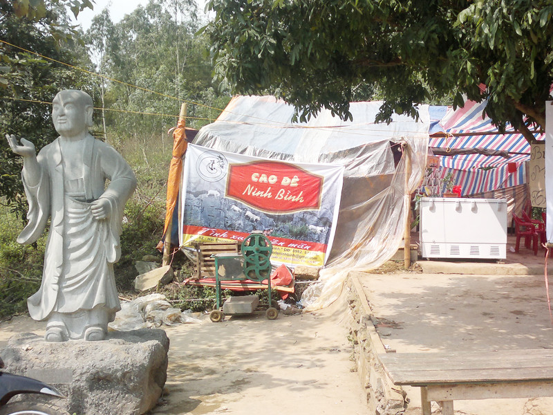 Bên tượng La Hán là biển Cao dê với quảng cáo: Cho tình xuân viên nãm ở chùa Bái Đính cổ. Bên tượng La Hán là biển Cao dê với quảng cáo: Cho tình xuân viên nãm ở chùa Bái Đính cổ