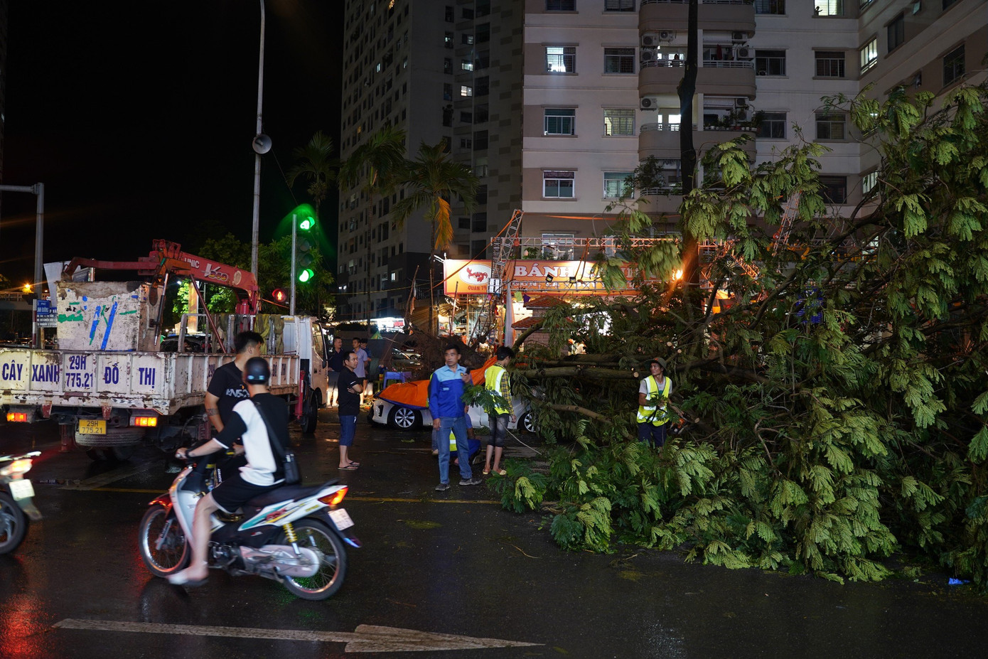 Khoảng 20h00, lực lượng chức năng có mặt để xử lý cây xanh gãy đổ giúp xe cộ lưu thông.