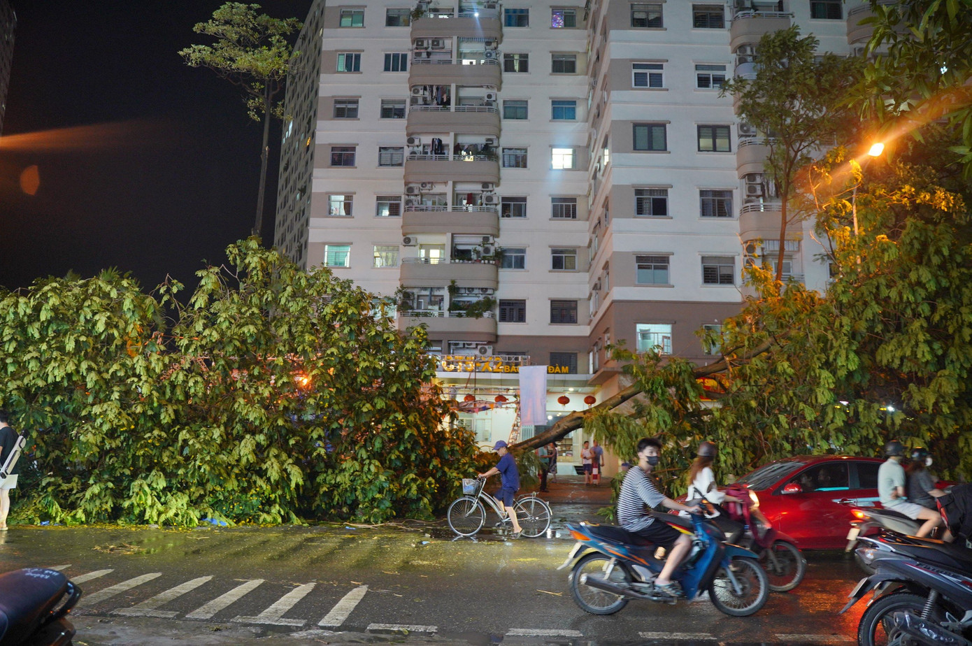 Ghi nhận của PV, trên các tuyến đường trong khu đô thị HH Linh Đàm (quận Hoàng Mai), nhiều cây lớn bật gốc đổ xuống đường, đè bẹp ô tô. Người dân ở đây cho biết, chỉ sau khoảng 10 phút mưa giông thì cây bất ngờ đổ xuống tạo tiếng kêu to, trúng ô tô, rất may không có thiệt hại về người.