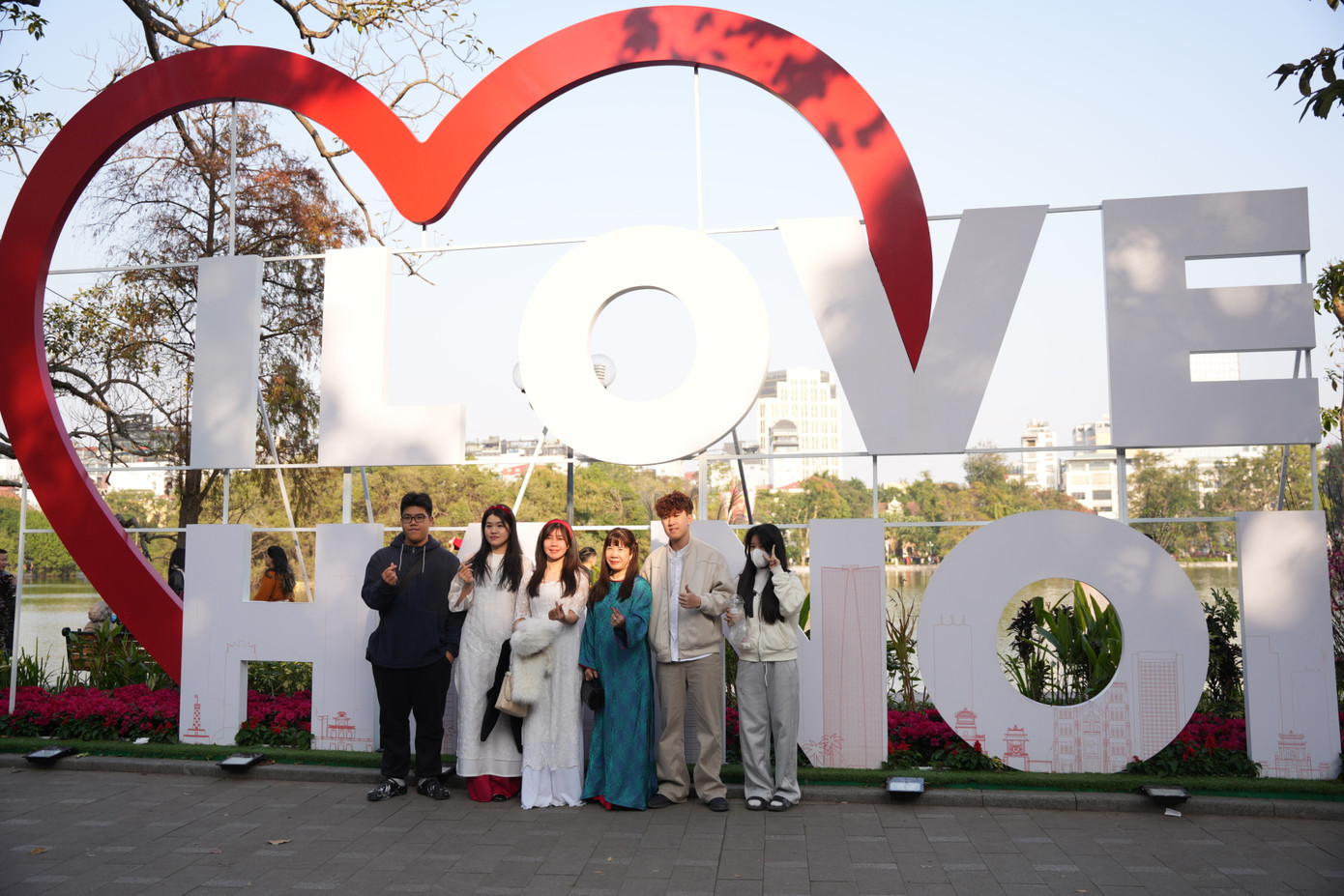 Các gia đình thảnh thơi dạo chơi trên bờ hồ Hoàn Kiếm, lưu giữ lại kỷ niệm. Các gia đình thảnh thơi dạo chơi trên bờ hồ Hoàn Kiếm, lưu giữ lại kỷ niệm.