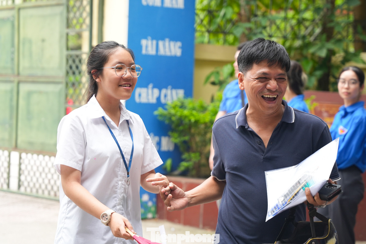 Người bố vui mừng nắm tay con khi nghe con gái thông báo làm bài thi tốt.