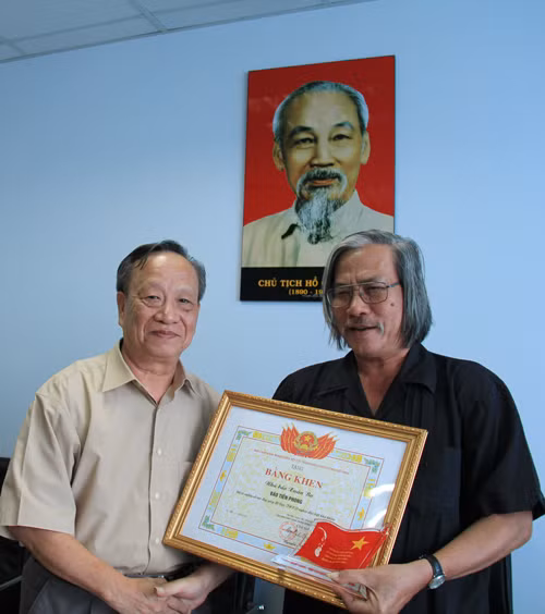 Ông Cù Văn Phiên – Phó Chủ tịch thường trực Hội Cựu TNXP Việt Nam trao bằng khen cho nhà báo Xuân Ba. Ảnh: Trường Phong