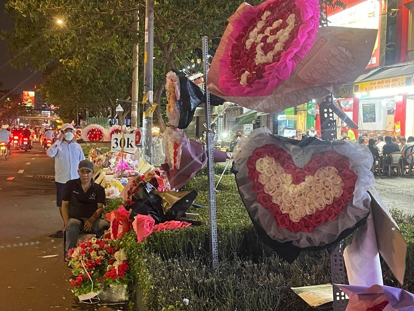 Anh Nhã đượm buồn vì hoa Valentine bán chậm trong khi đêm đã dần khuya. Ảnh: KHÁNH TRÚC