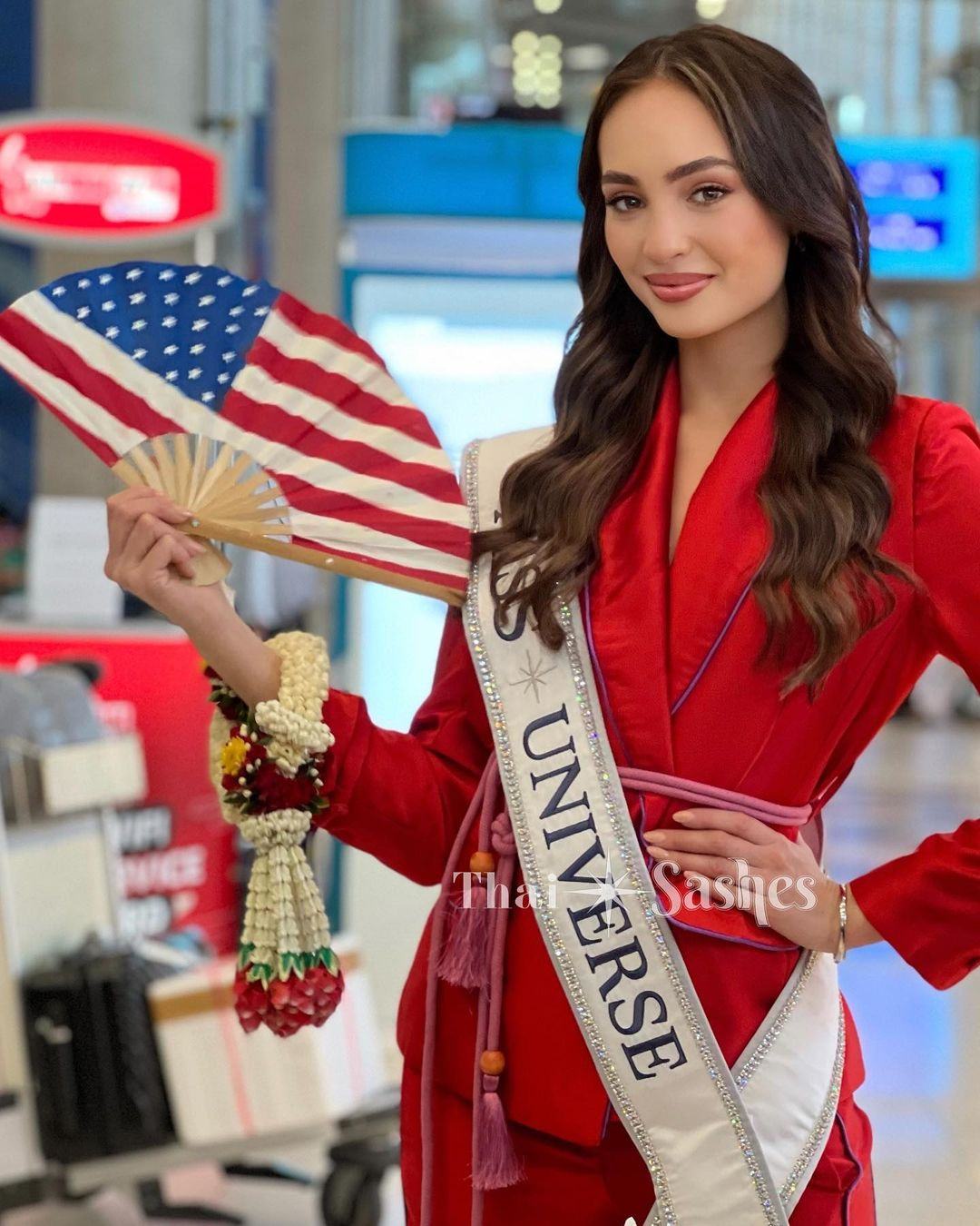 Xuất hiện ở sân bay, người đẹp Mỹ diện bộ trang phục tông màu đỏ kín đáo, sang trọng. Cô gửi nụ hôn gió tới các fan đến sân bay để chào đón mình. R'Bonney Gabriel được yêu mến ở Đông Nam Á vì cô là người đẹp gốc Á, lai Mỹ - Philippines.