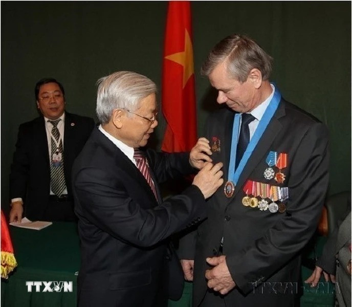 Tổng Bí thư Nguyễn Phú Trọng tặng Huy hiệu Bác Hồ cho đại diện các cựu chiến binh Nga chiến đấu tại Việt Nam, nhân chuyến thăm chính thức Liên bang Nga (Mátxcơva, 2014). (Ảnh: Trí Dũng/TTXVN)