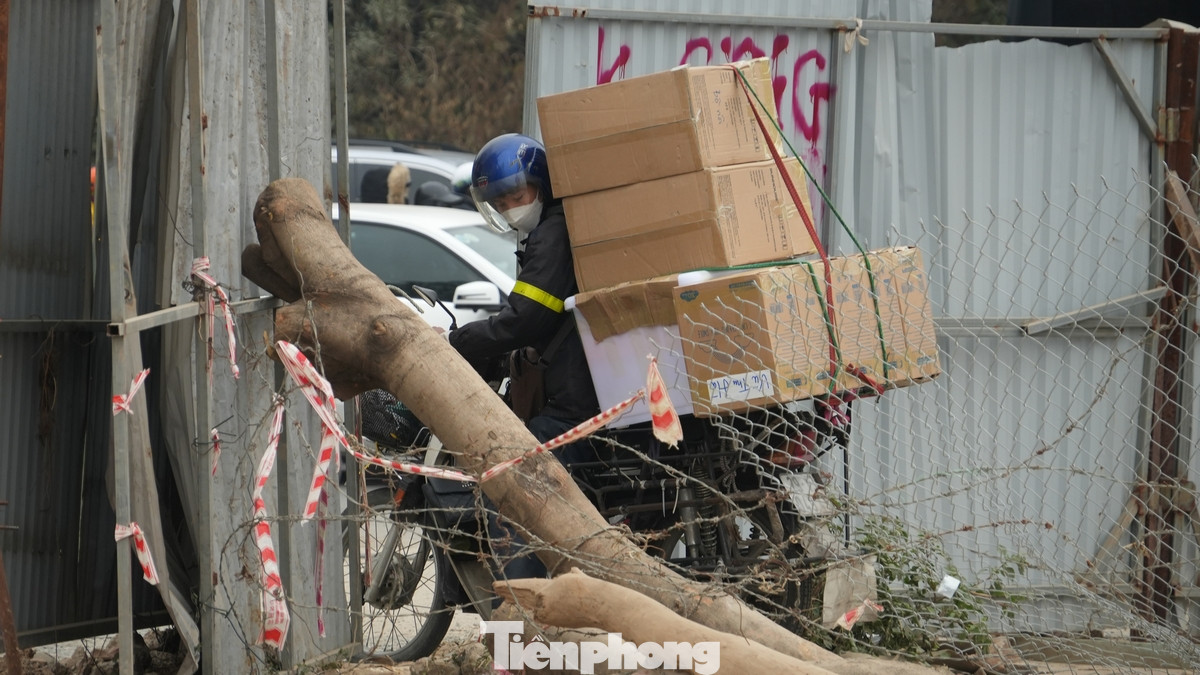 Xe máy chở hàng cồng kềnh cũng cố lách qua đoạn hàng rào của dự án.