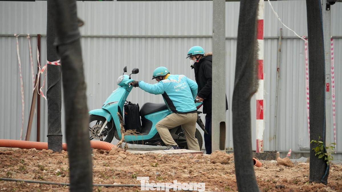 Nhiều người đi đến cuối đường, không có lối sang nên nâng và dắt xe trên vỉa hè của đoạn đường Lê Quang Đạo đang thi công dở dang.