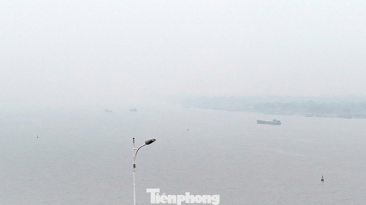 Những chiếc tàu lớn di chuyển trên sông Hồng mờ ảo trong làn sương dày đặc được phóng viên ghi lại vào buổi trưa nay (22/1).