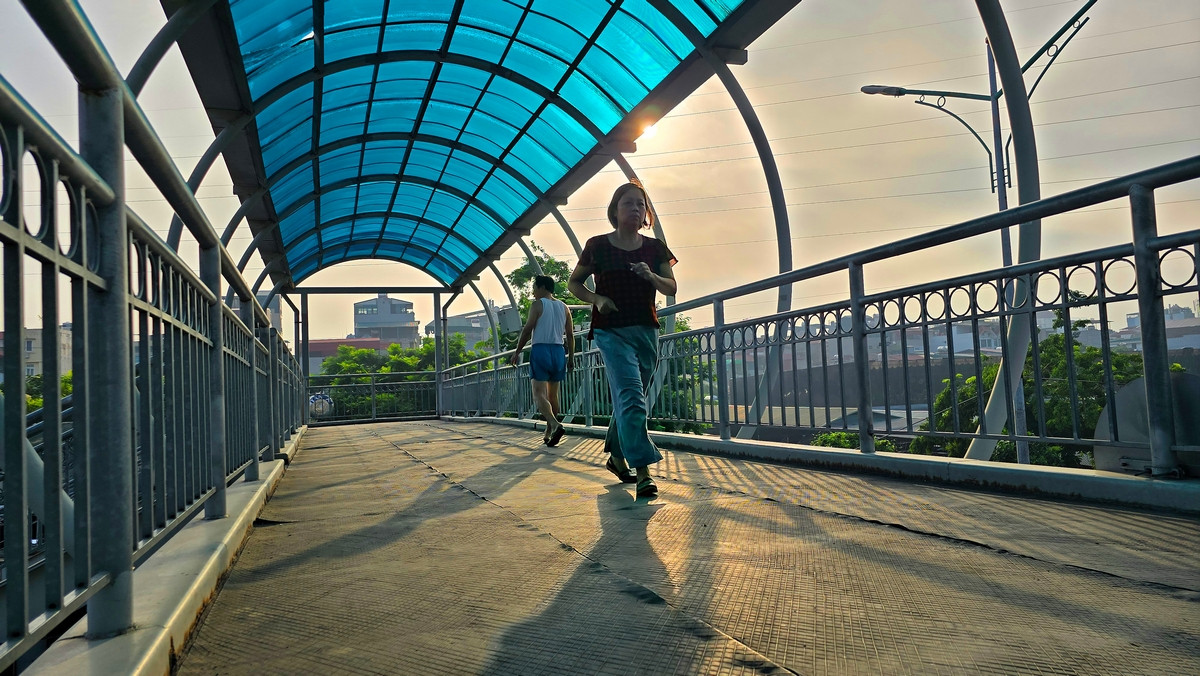 Người dân tranh thủ tập thể dục buổi sáng dưới mái che của cầu vượt hoặc dưới bóng cây để hạn chế tia tử ngoại. Người dân tranh thủ tập thể dục buổi sáng dưới mái che của cầu vượt hoặc dưới bóng cây để hạn chế tia tử ngoại.