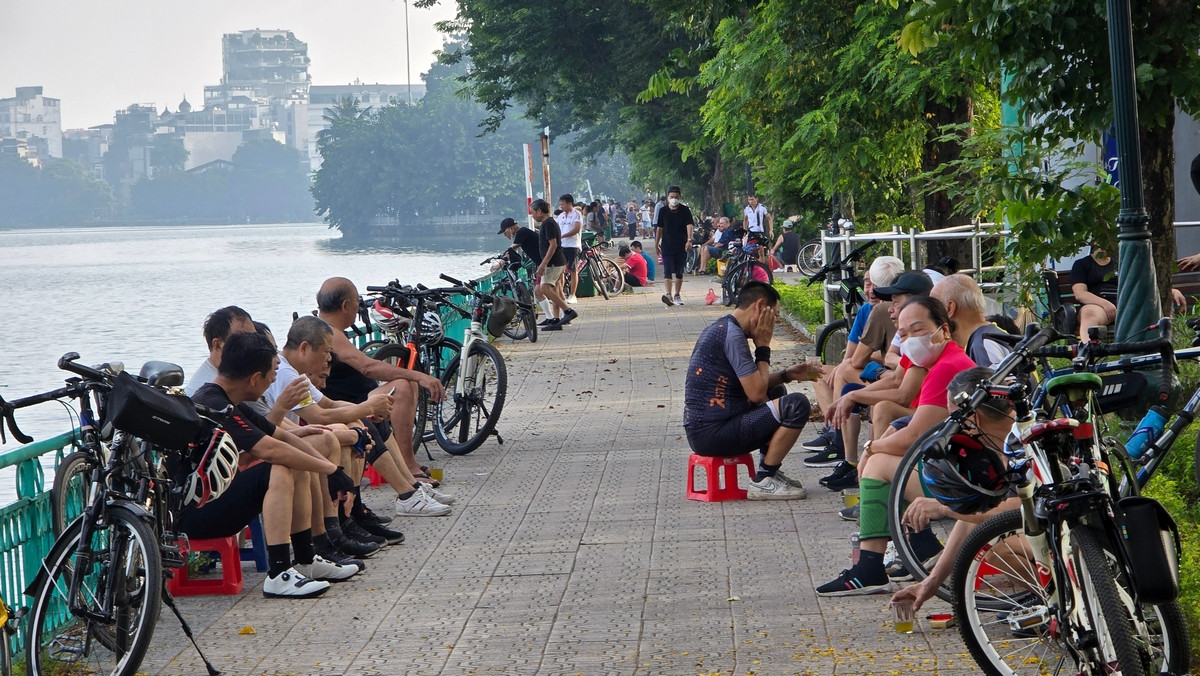 Nhiều người ngồi bên bờ Hồ Tây để giảm nhiệt sau thời gian tập thể dục. Nhiều người ngồi bên bờ Hồ Tây để giảm nhiệt sau thời gian tập thể dục.
