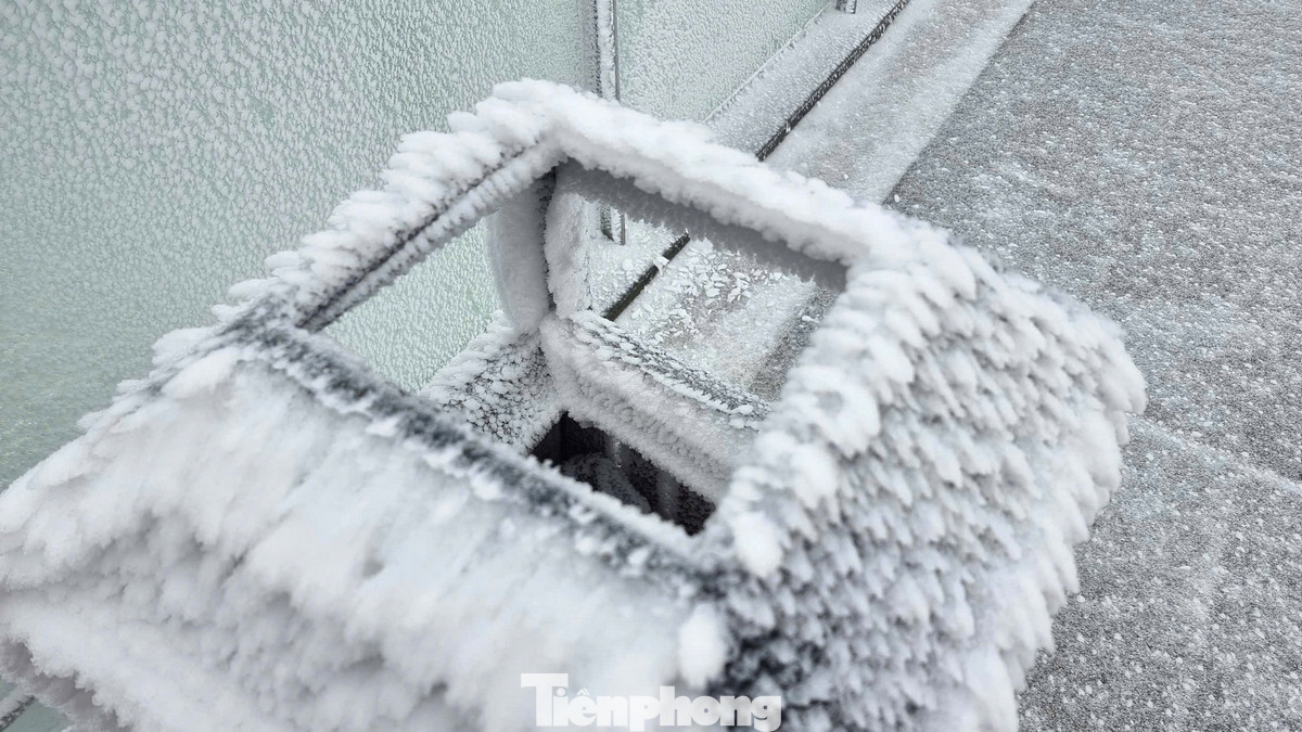 Tuyết rơi phủ trắng sàn gỗ khu đặt biểu tượng Fansipan và cây, cỏ trên đỉnh núi. Hiện tại, nhiệt độ tại đỉnh Fansipan chỉ khoảng -2 độ C.