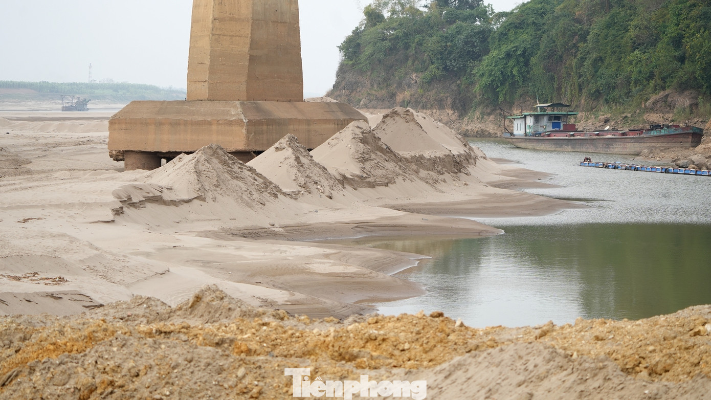 Nước sông Hồng cạn, lộ nhiều bãi đá ngầm khiến hoạt động giao thông đường thủy qua đây gặp nhiều khó khăn.