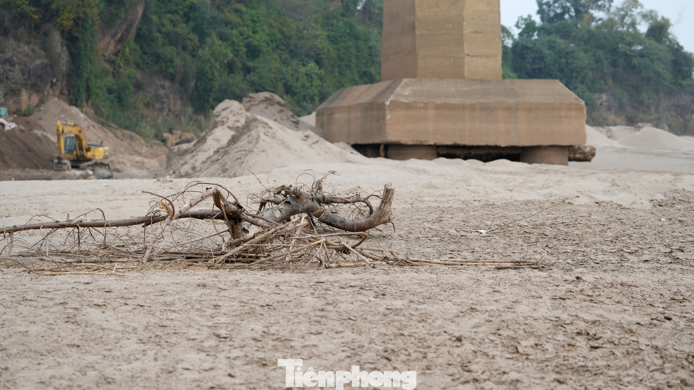 Nước sông Hồng cạn, lộ nhiều bãi đá ngầm khiến hoạt động giao thông đường thủy qua đây gặp nhiều khó khăn.