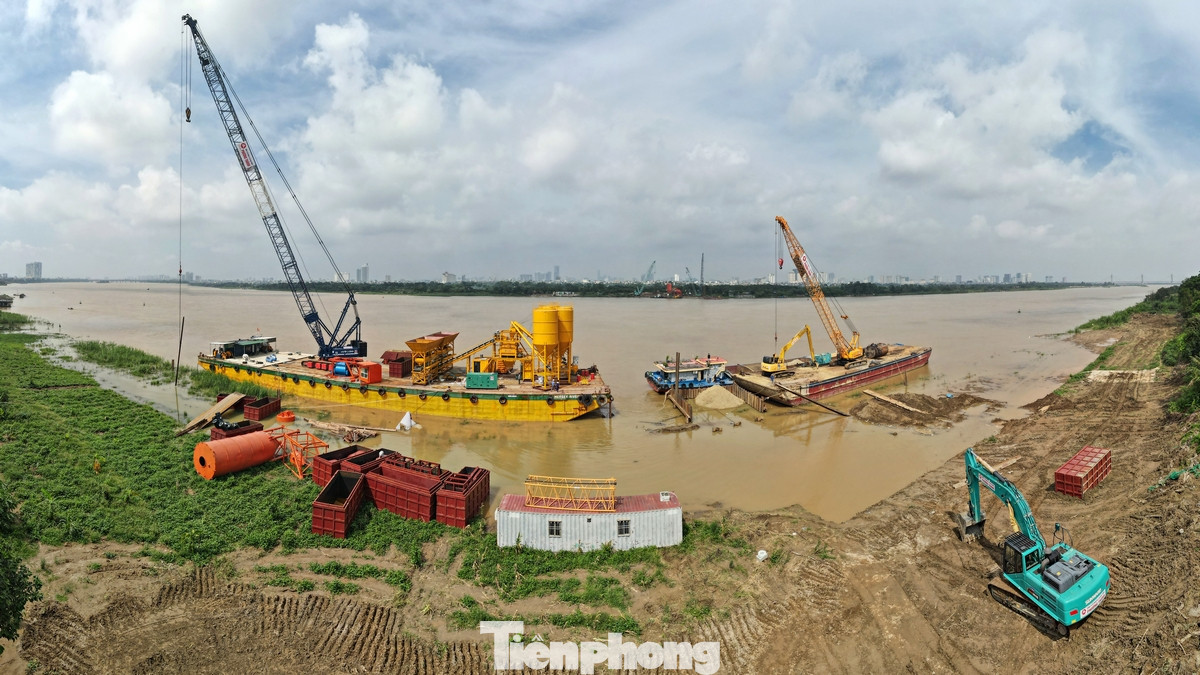 Công nhân cùng các trang thiết bị máy móc đang thi công trụ cầu phía quận Long Biên.