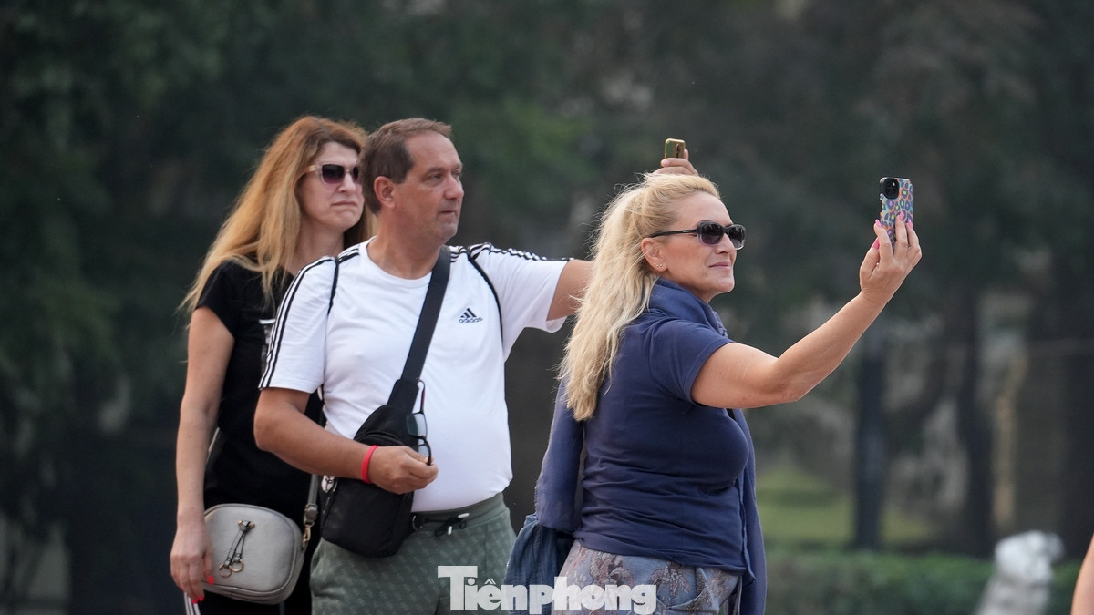 Khách du lịch quốc tế thích thú check-in trước những biểu ngữ, pano đón chào năm mới.