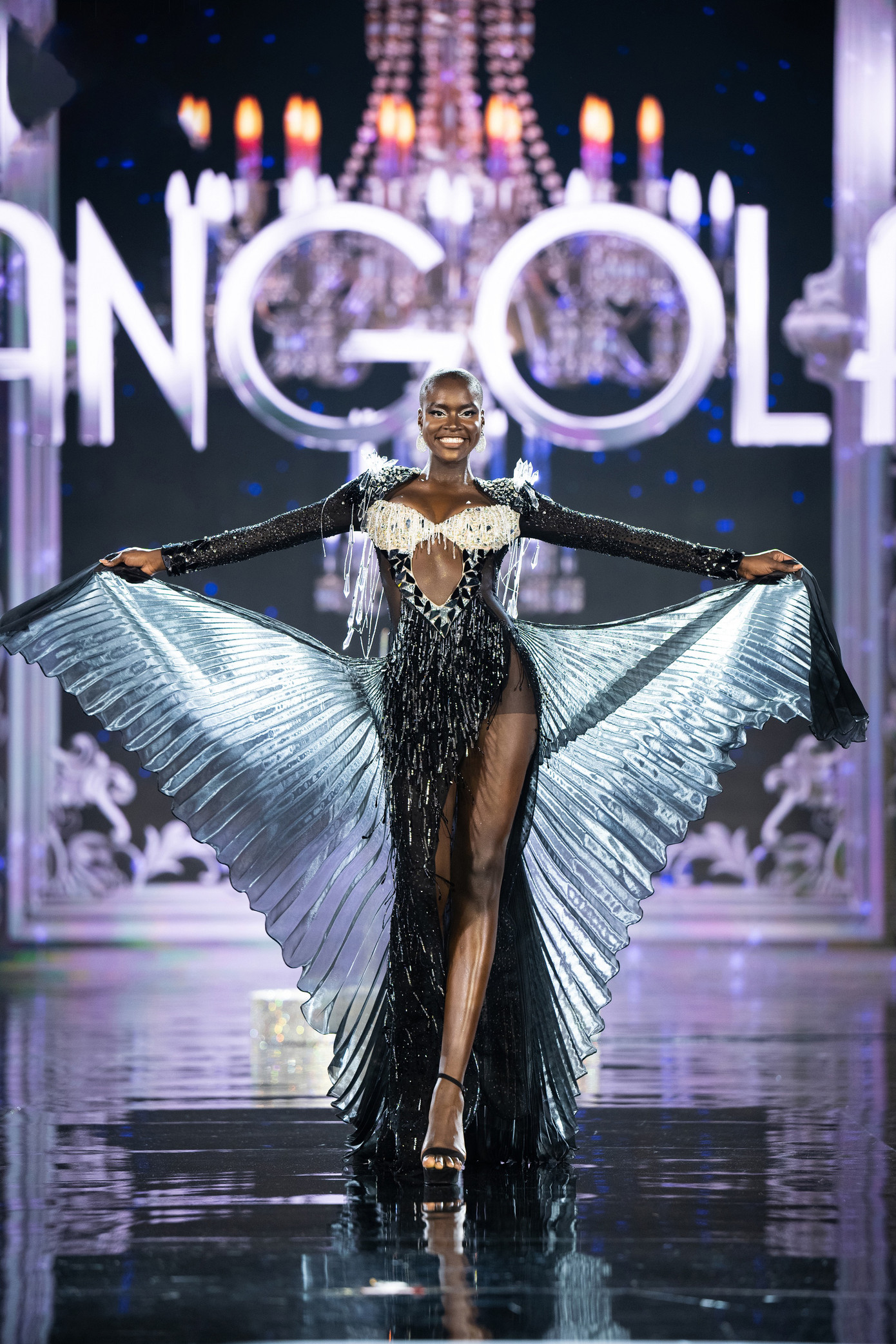 Đại diện Angola là thí sinh hiếm hoi chọn váy dạ hội màu đen, kết hợp phần tà xếp ly. Phong thái trình diễn của cô được đánh giá chuyên nghiệp, đẹp mắt.
