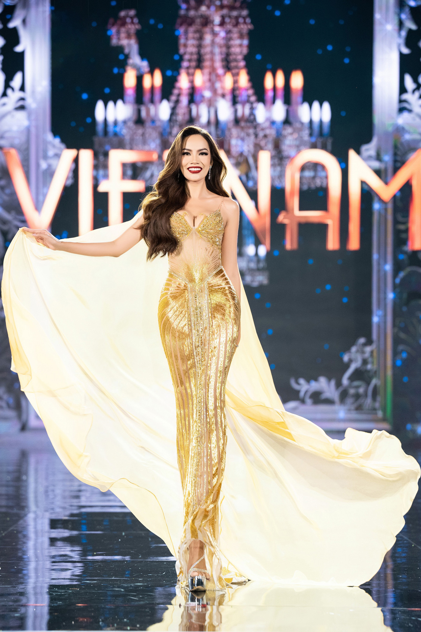 Đại diện Việt Nam - Lê Hoàng Phương diện váy tông màu vàng gold, kết hợp phần tà bay bổng. Nhà thiết kế sử dụng công nghệ thiết kế 3D tạo hình hai chú chim thiên nga e ấp ôm trọn phần ngực đầy tinh tế, kết hợp cùng sự uyển chuyển của chất liệu bay bổng. Phần thân dưới được đính kết hạt cườm giúp bắt sáng trên sân khấu. Lê Hoàng Phương thể hiện kỹ năng trình diễn chuyên nghiệp với những bước đi tự tin, xoay váy chắc chắn.