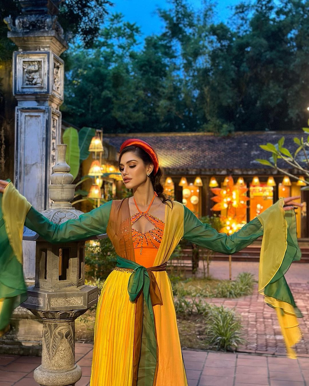 Isabella Menin mặc áo tứ thân rực rỡ màu sắc khi đi thăm chùa Thầy trong chuỗi hoạt động của cuộc thi diễn ra ở Hà Nội. Vẻ đẹp dịu dàng của người đẹp nhận nhiều lời khen.