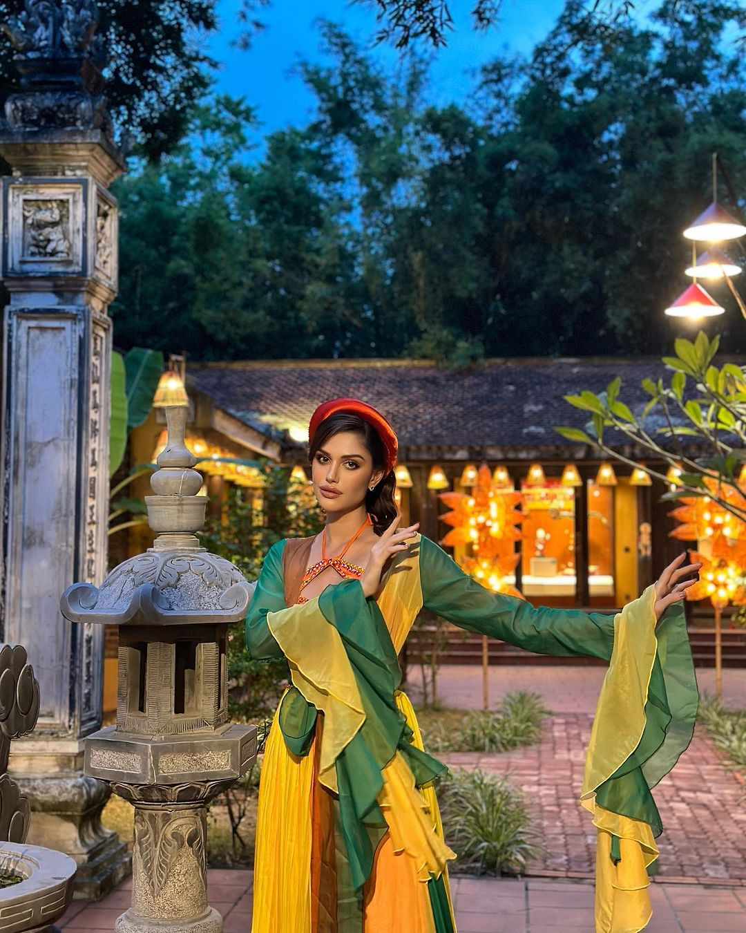 Isabella Menin mặc áo tứ thân rực rỡ màu sắc khi đi thăm chùa Thầy trong chuỗi hoạt động của cuộc thi diễn ra ở Hà Nội. Vẻ đẹp dịu dàng của người đẹp nhận nhiều lời khen.