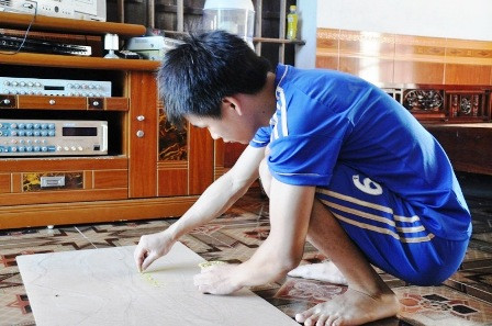 Gắn vật liệu vào bức tranh là công đoạn cần sự tỉ mỉ và kiên trì.