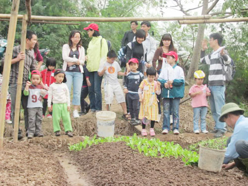 Các bé được hướng dẫn cách trồng rau. Ảnh: Hồng Minh