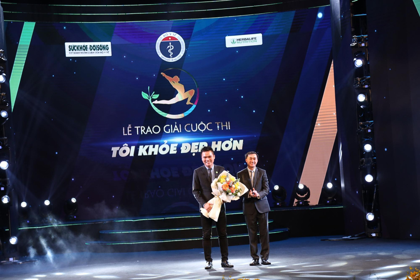 Đồng chí Trần Văn Thuấn - Thứ trưởng Bộ Y tế, Trưởng ban Chỉ đạo cuộc thi tặng hoa đại diện nhà tài trợ Herbalife Nutrition