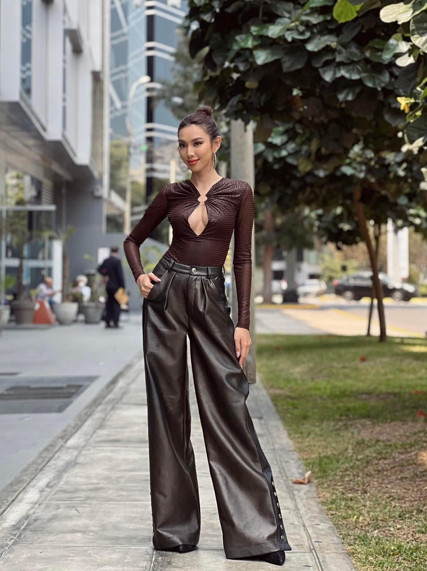 Người đẹp phối quần da dáng xuông với áo xẻ vòng một táo bạo.