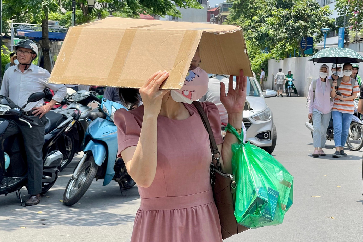 Người dân tìm cách chống chọi với cái nắng khi phải di chuyển trên đường. Người dân tìm cách chống chọi với cái nắng khi phải di chuyển trên đường.