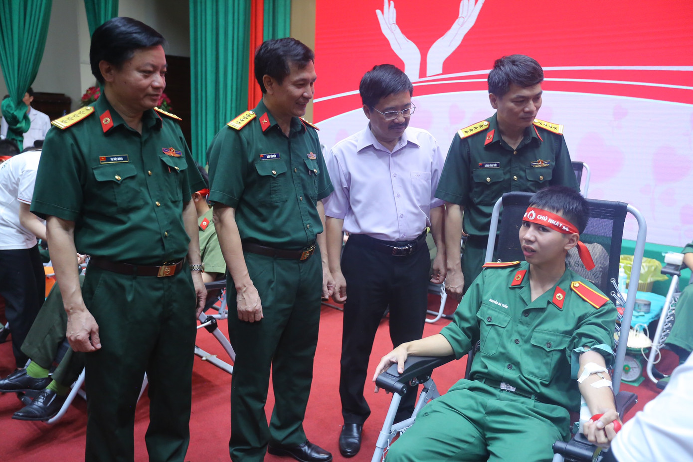 Các đại biểu thăm hỏi các bạn trẻ tham gia hiến máu.