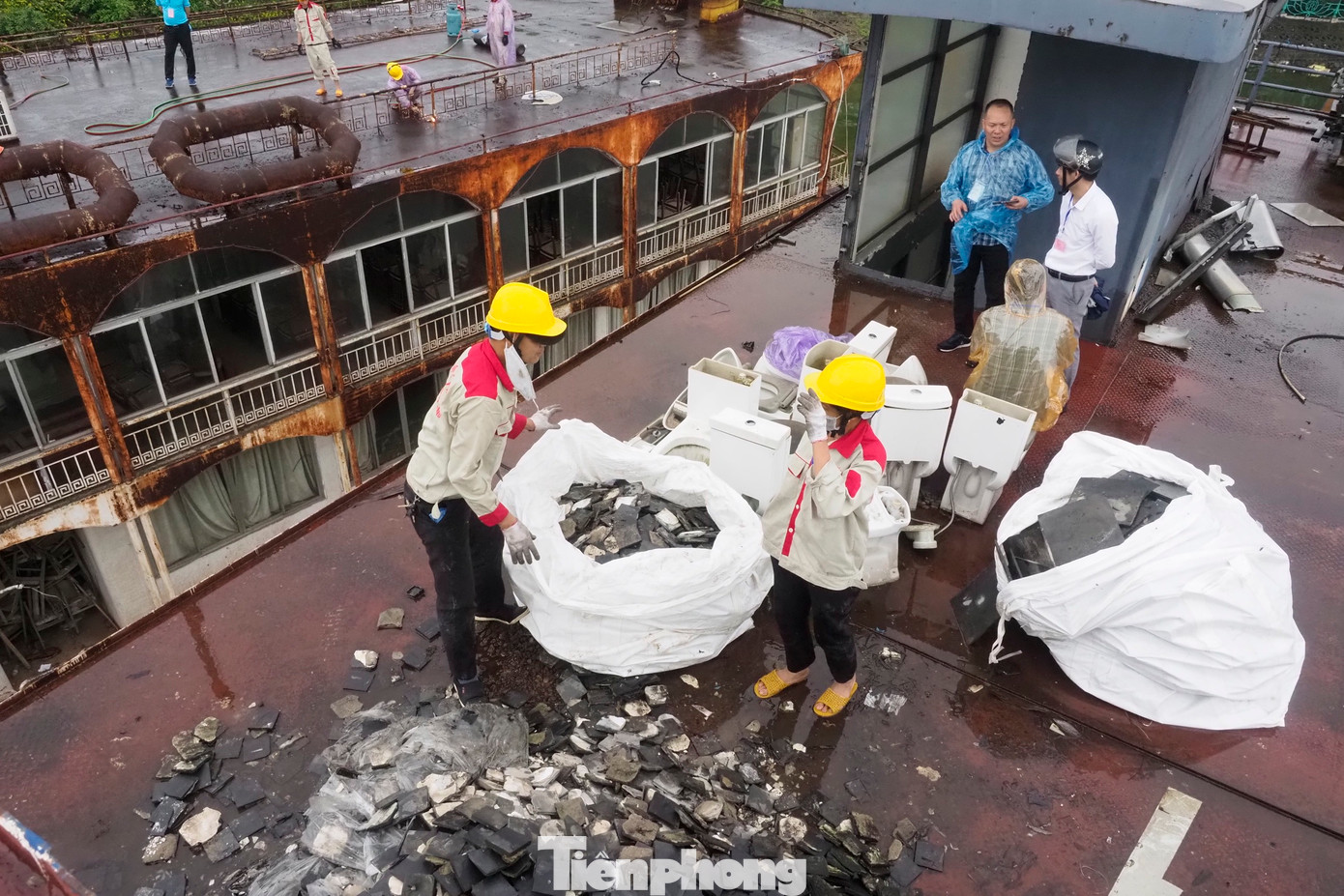 Công nhân đội mưa dọn rác trên tầng trên cùng của du thuyền.