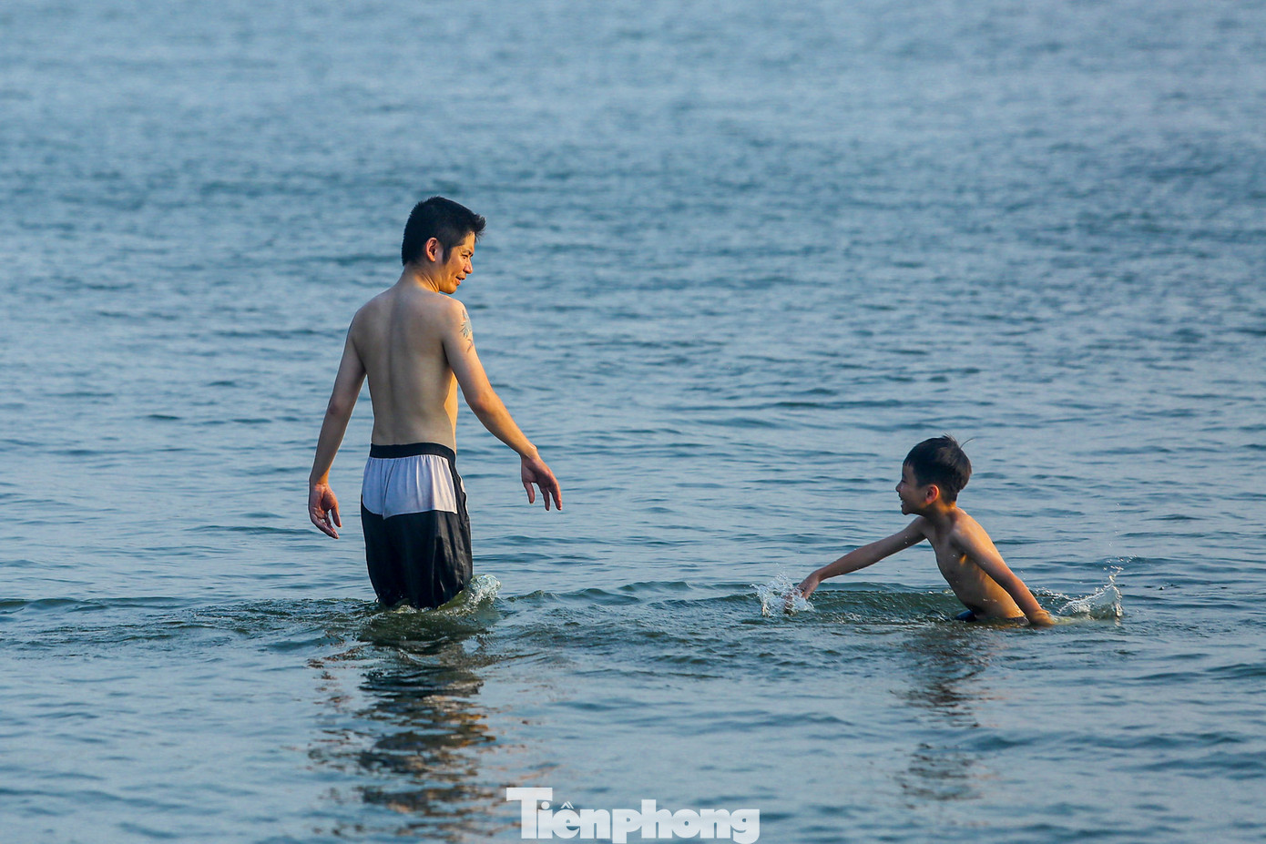 Hai cha con vui chơi dưới làn nước hồ Tây