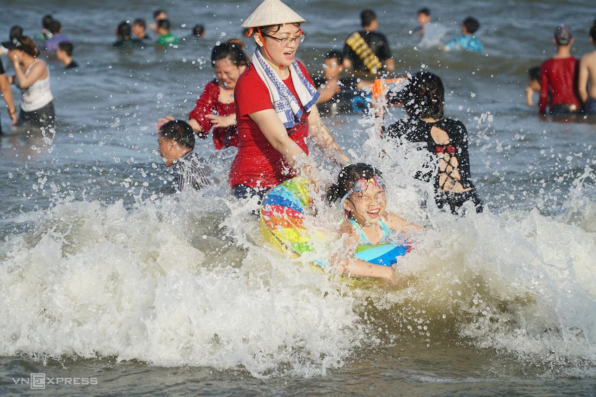 Cô bé được mẹ kéo phao vui đùa với sóng. Cô bé được mẹ kéo phao vui đùa với sóng.