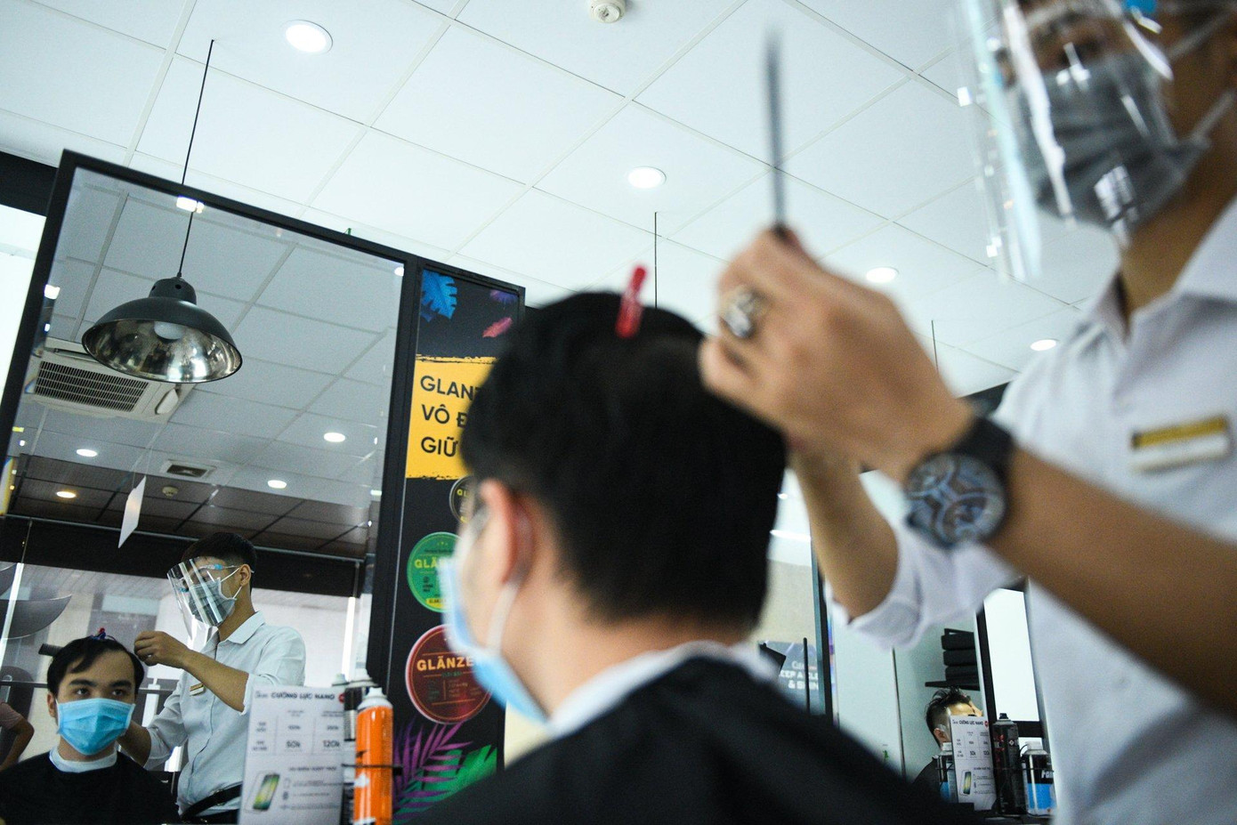 Cả khách hàng và nhân viên cắt tóc tuân thủ đeo khẩu trang để đảm bảo phòng dịch COVID-19.