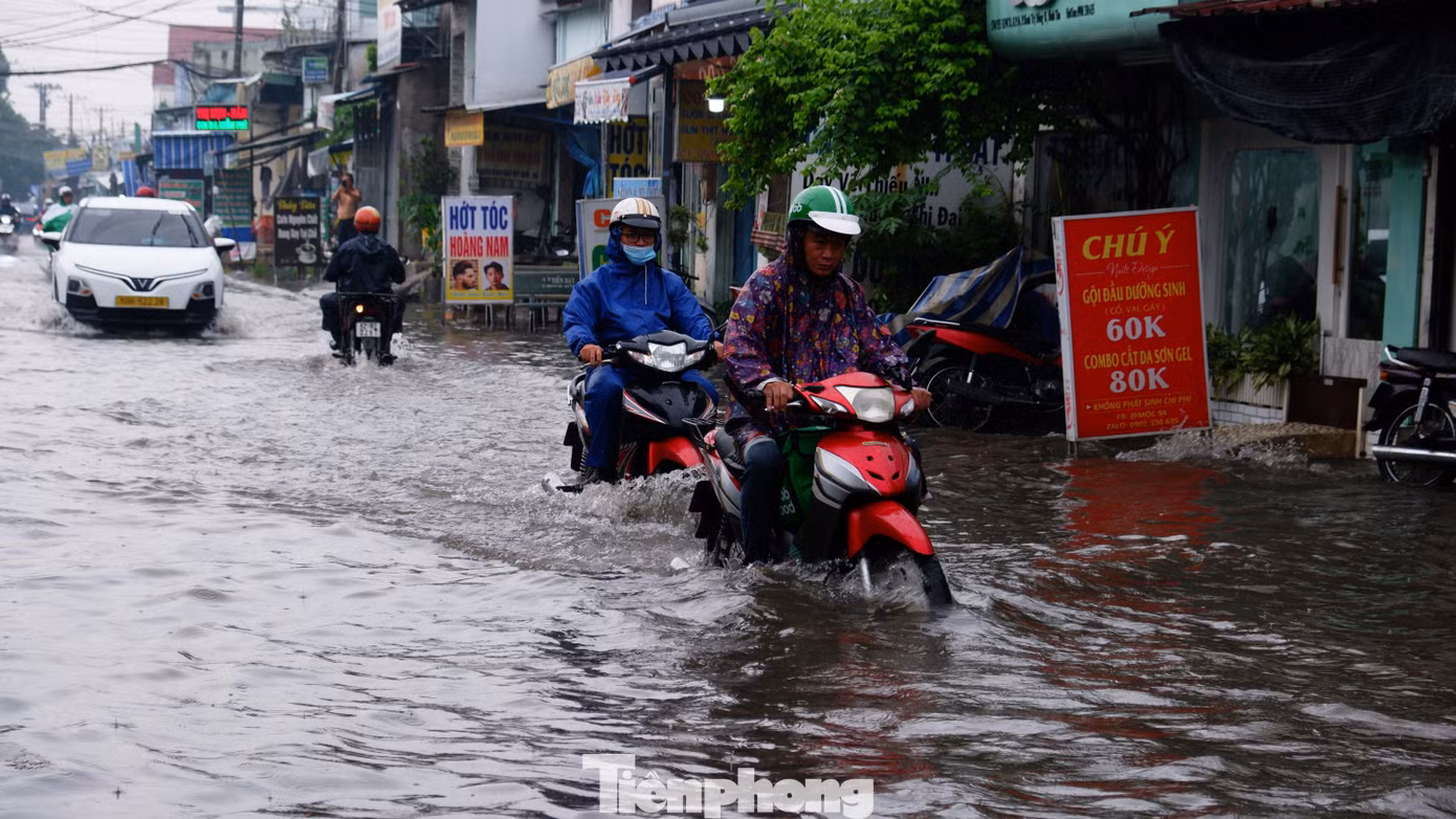 Người và phương tiện bì bõm lội nước sau mưa lớn.