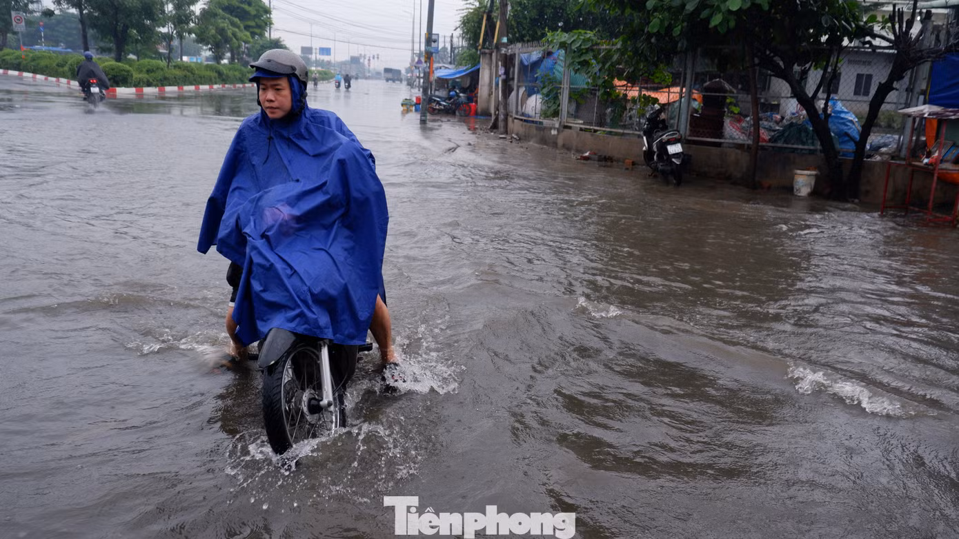 Người và phương tiện bì bõm lội nước sau mưa lớn.