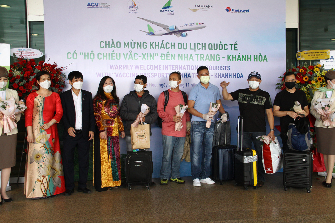 Lãnh đạo ngành du lịch Khánh Hoà và sân bay Cam Ranh tặng hoa cho du khách quốc tế