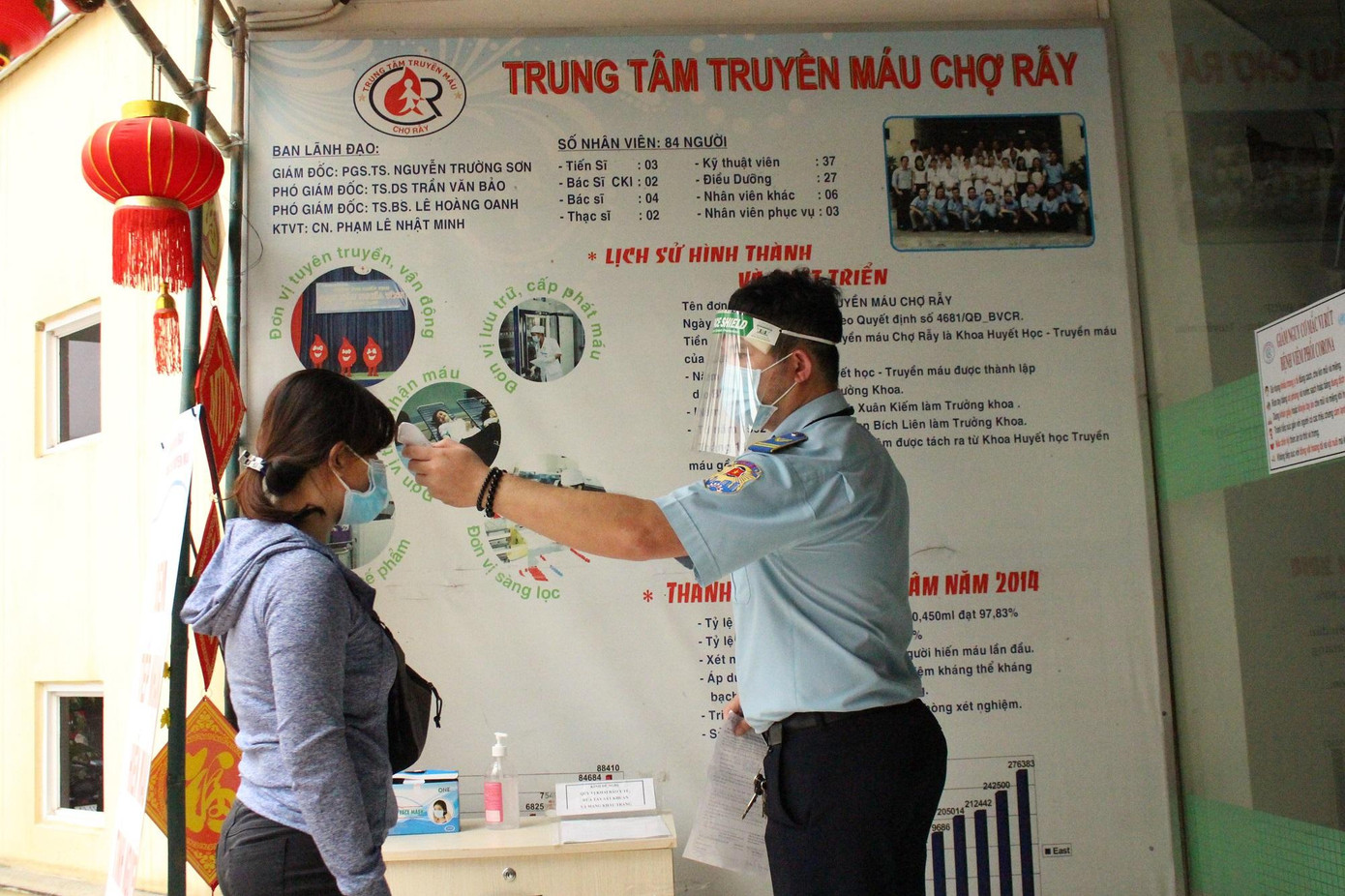 Công tác kiểm soát nguy cơ được siết chặt ngay trong bệnh viện, nhân viên bảo vệ đang đo thân nhiệt cho người đến hiến máu.