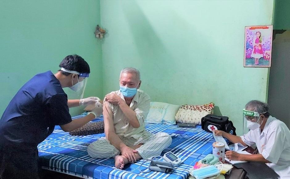 Nhân viên y tê đang đi từng ngõ, gõ từng nhà để chích ngừa cho người dân