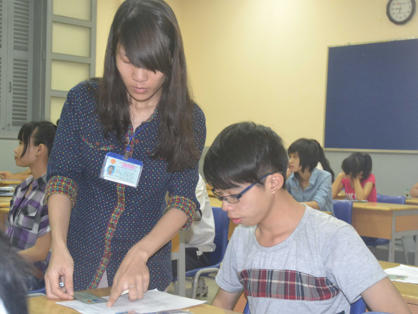 Giám thị tại điểm thi Trường THPT Nguyễn Thị Minh Khai, điểm thi của trường ĐH Y Khoa Phạm Ngọc Thạch đối chiếu hình của thí sinh trong giấy báo dự thi và chứng minh thư của thí sinh. Ảnh: Quang Phương