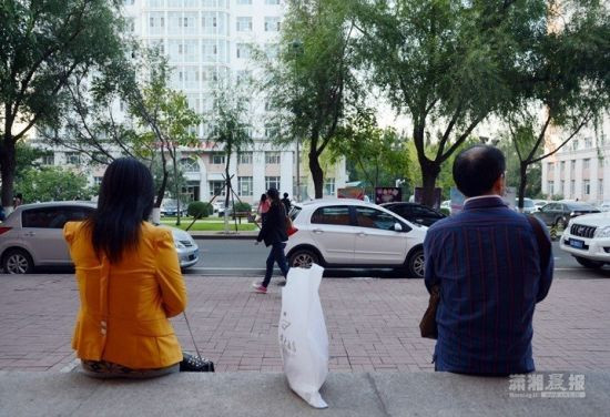 Cha mẹ Chen ngồi bên ngoài trường chờ con