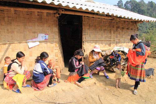Gần trưa, khi ánh mặt trời ló qua các đỉnh núi mây mù, phụ nữ Mông gọi nhau địu con ra hiên nhà ngồi sửa ấm, tranh thủ thêu thùa váy áo mới chuẩn bị đi chơi Tết