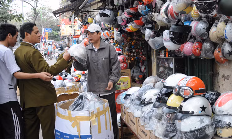 Lực lượng quản lý thị trường kiểm tra các cơ sở kinh doanh mũ bảo hiểm trên phố Huế (quận Hai Bà Trưng, Hà Nội) ngày 8-3. Ảnh: Tuấn Nguyễn