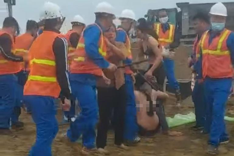 Nhóm người phụ nữ mặc áo ngực xô xát với những người đàn ông mặc đồng phục ở công trường. Ảnh cắt từ clip